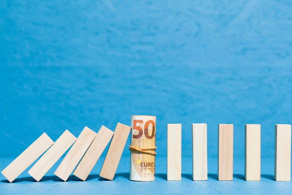 Simboli di bancarotta con pezzi di legno caduti e banconota in primo piano