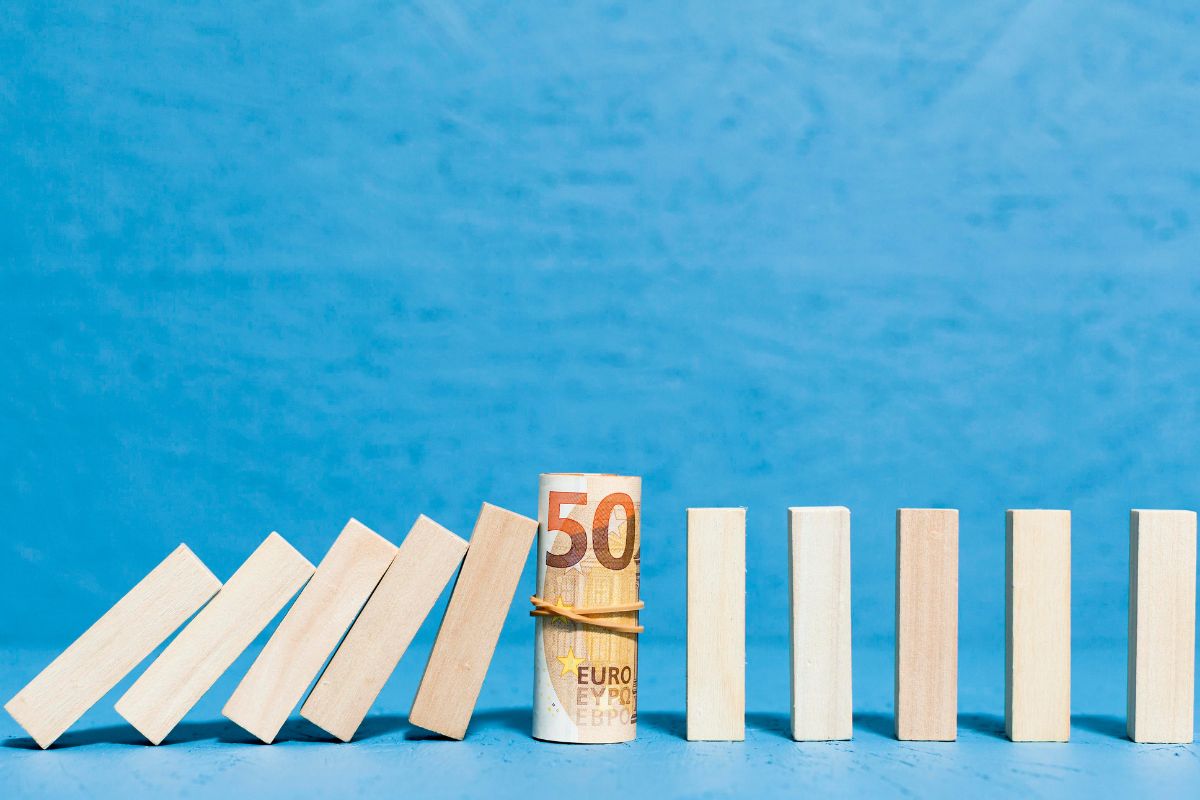 Simboli di bancarotta con pezzi di legno caduti e banconota in primo piano